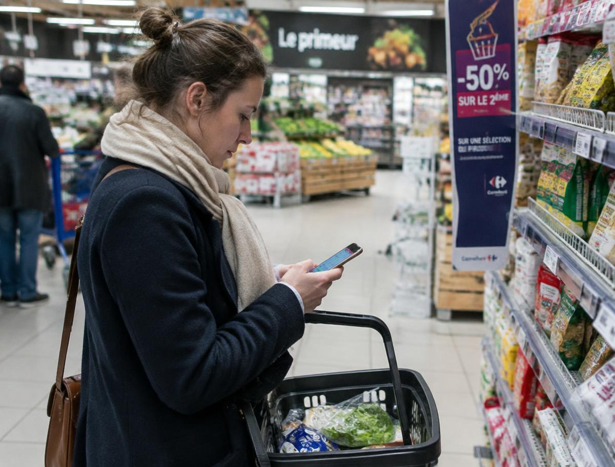 Salariée faisant ses courses avec son téléphone